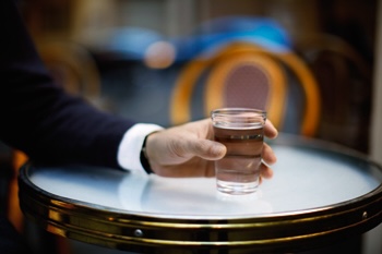 Photo d'un verre d'eau tenu par une main.